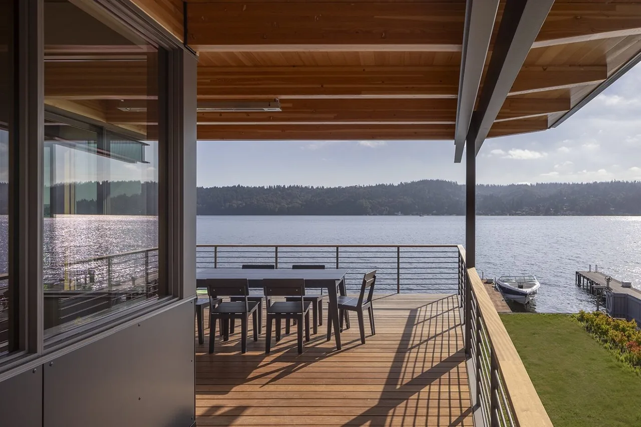 The Lake Washington Residence features a covered patio deck with metal railing and wood ceiling, offering lake views.