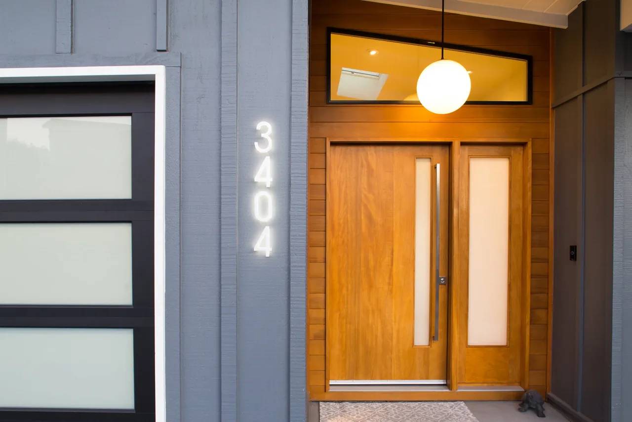 The Belmont Country Club project features a wooden front door with frosted glass and a glowing house number 3404 on gray siding.