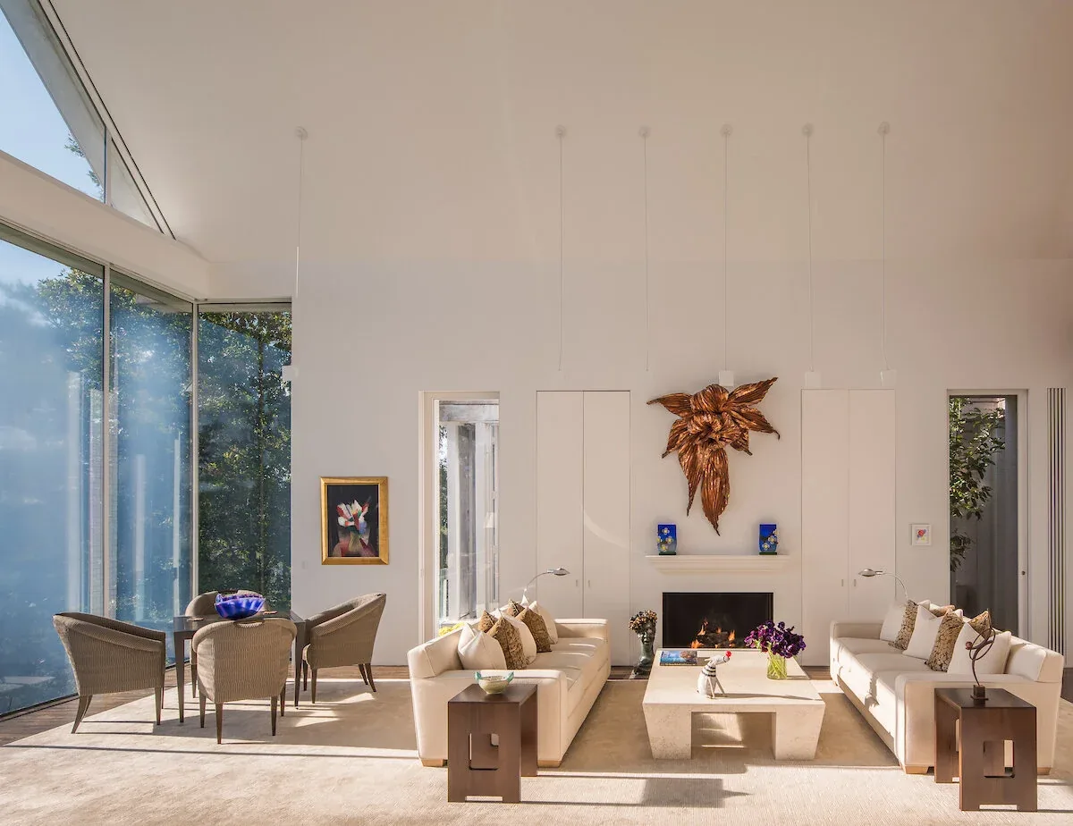 The Mills Residence living room with floor-to-ceiling corner glass walls offering natural light and views to the outdoors.