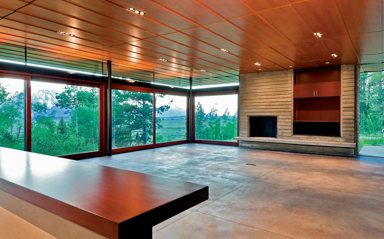 Lost Creek Cabin living room with concrete floor, wood ceiling, floor-to-ceiling windows, and a built-in fireplace wall.