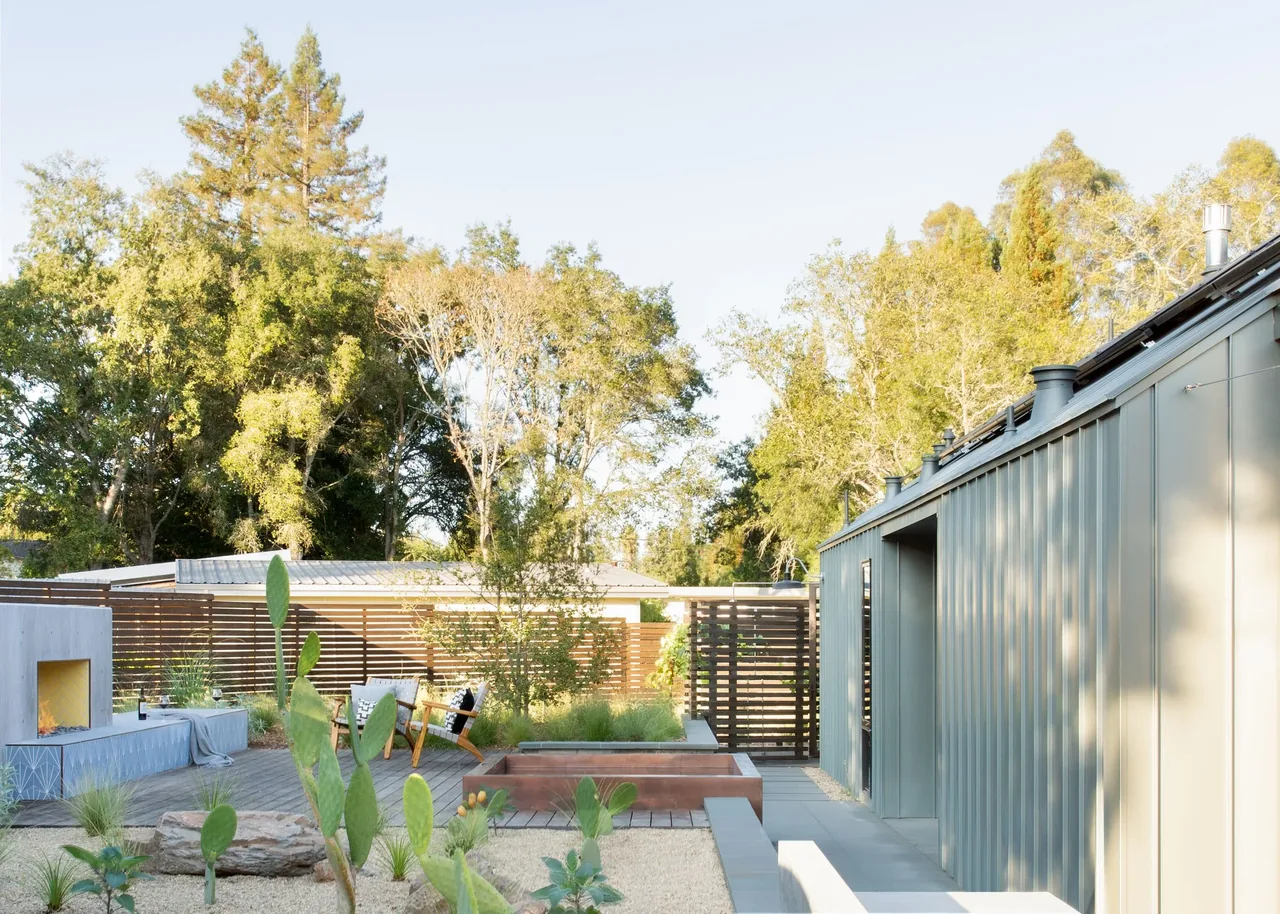 The Sonoma Farmhaus outdoor lounge features a contemporary seating area with a fireplace and metal roof siding.