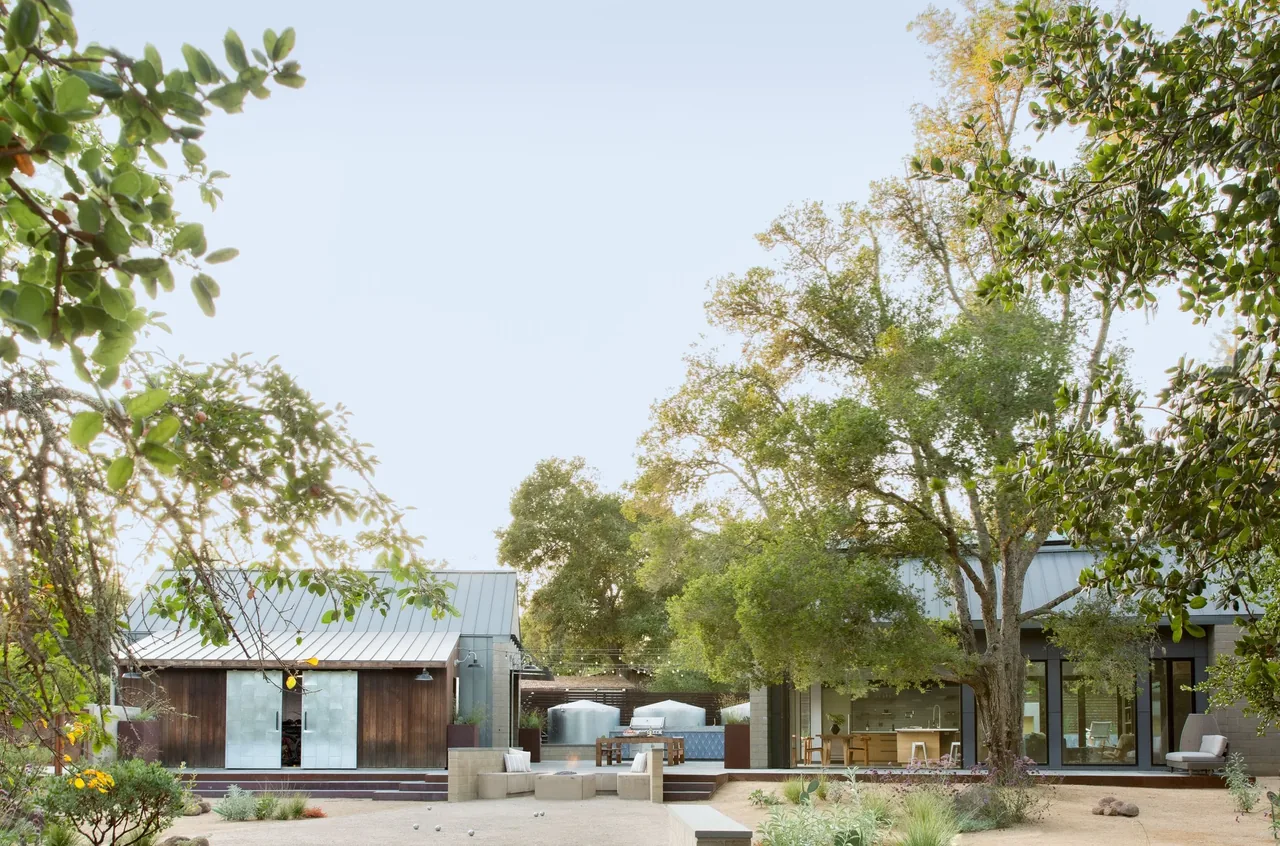 Sonoma Farmhaus features metal roofs, wooden siding, and an outdoor seating area with string lights and planter boxes.