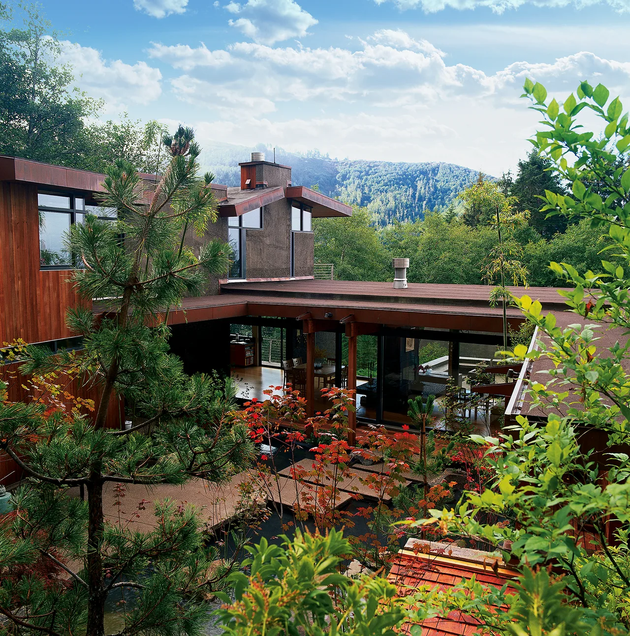 Horizon Hill House features a wood and concrete exterior integrated with its forested mountain setting.