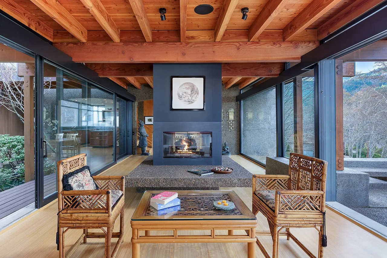 Horizon Hill House living space with exposed wood ceiling beams and a central double-sided fireplace connecting indoors and outdoors.