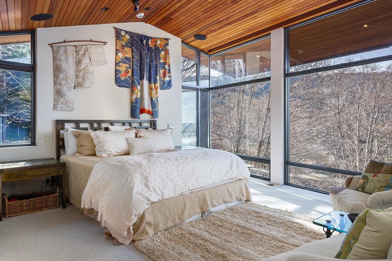 Bedroom featuring floor-to-ceiling windows and a wood-paneled ceiling with natural light.