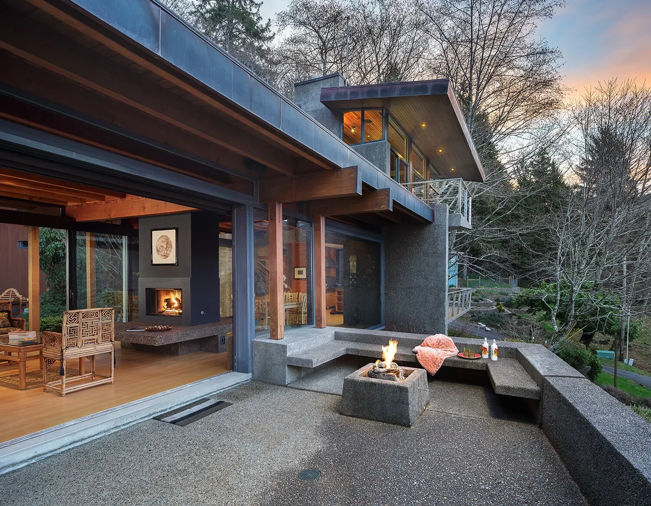 HORIZON HILL HOUSE features a stone seating area and fire pit on the patio with views of forest and mountain landscape.