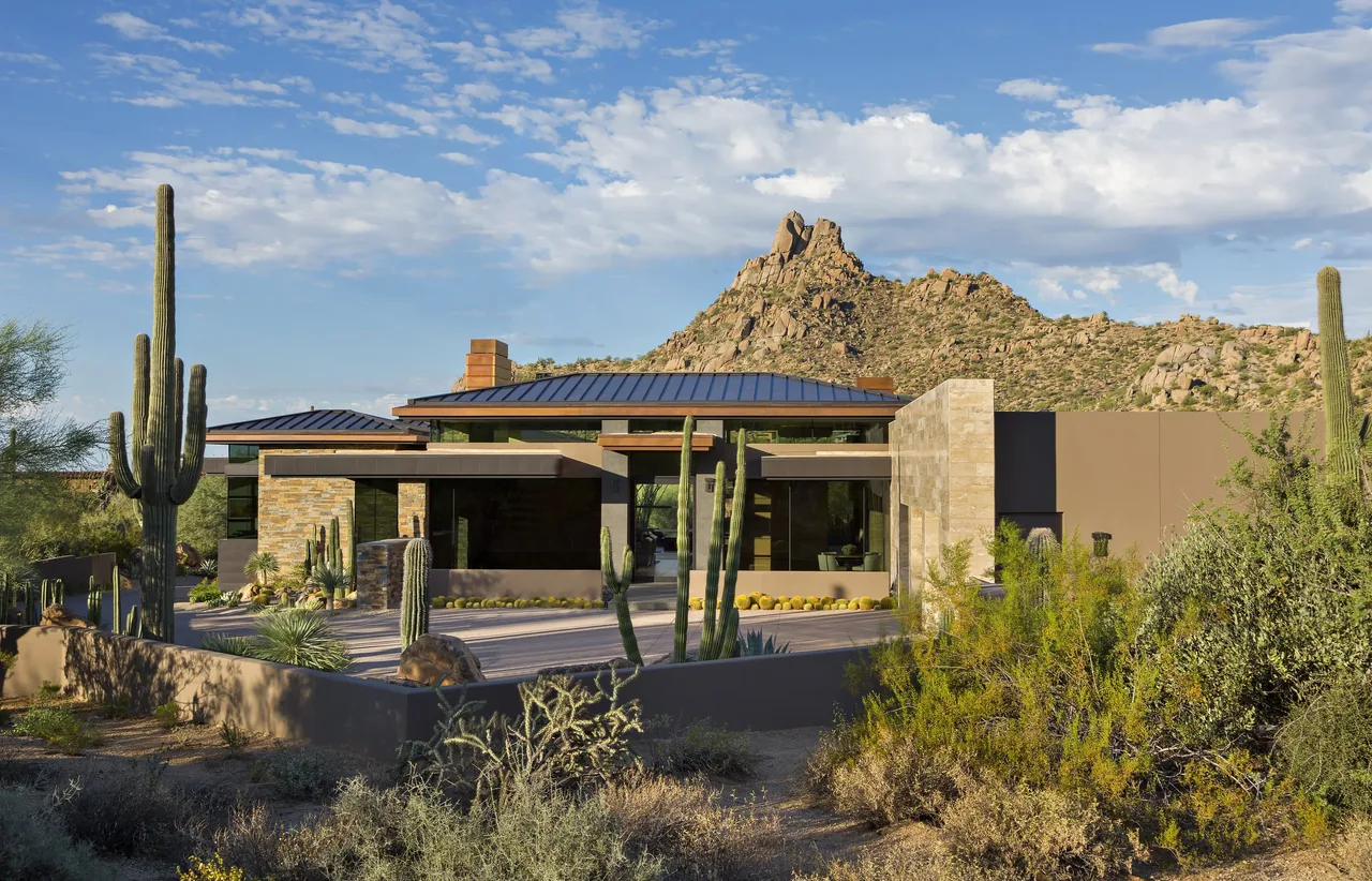 Silversmith Residence by Tate Studio Architects features a modern design with stone and stucco facade blending into the desert landscape.