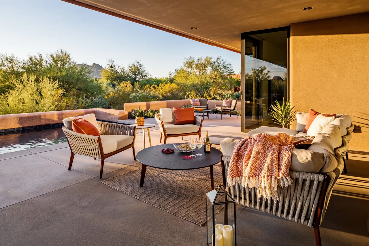 Outdoor living space at Shea-Naito Residence featuring wicker furniture and a coffee table on a covered patio.