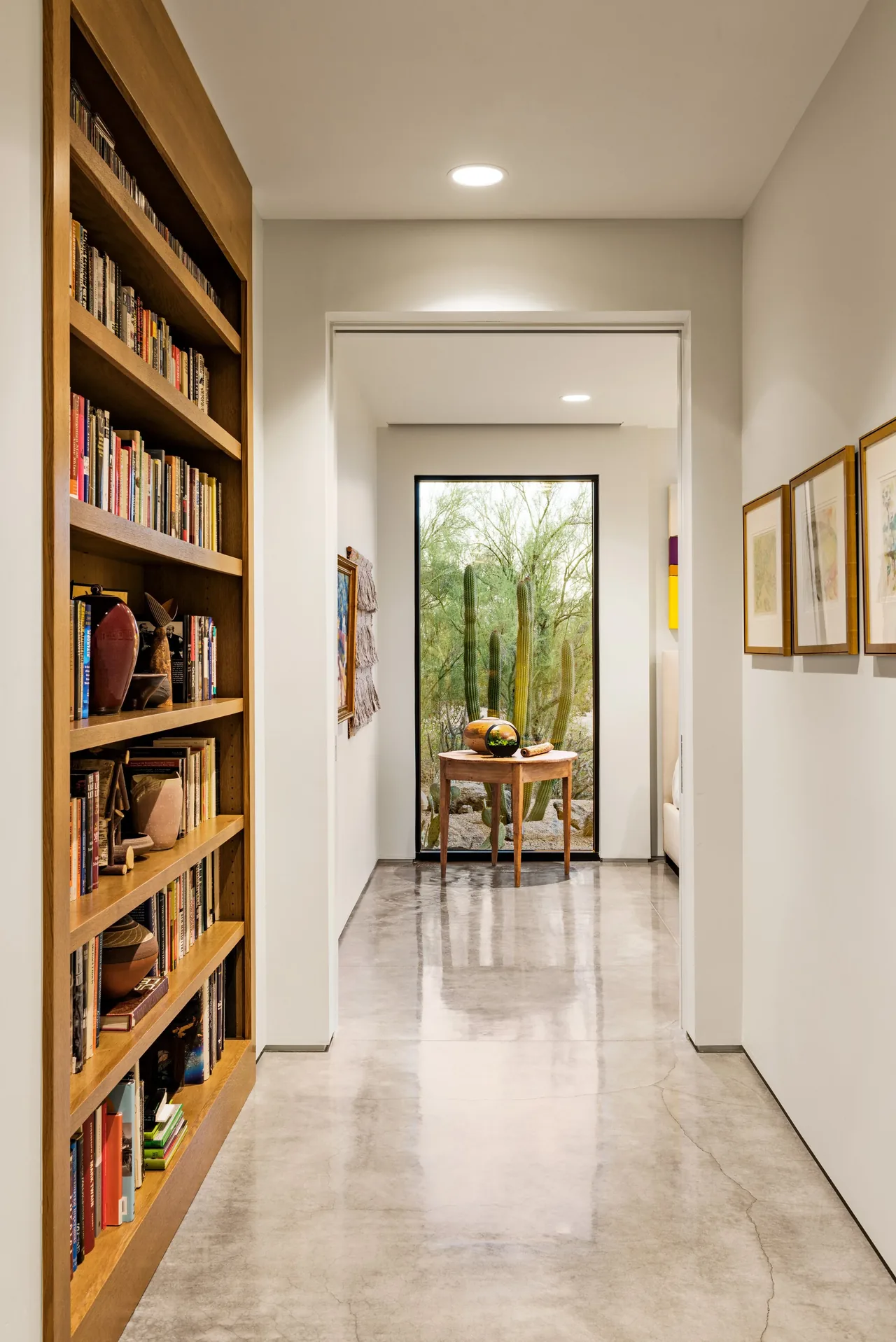 Hallway features polished concrete flooring and a window with desert landscape view, part of the Shea-Naito Residence by Tate Studio Architects.