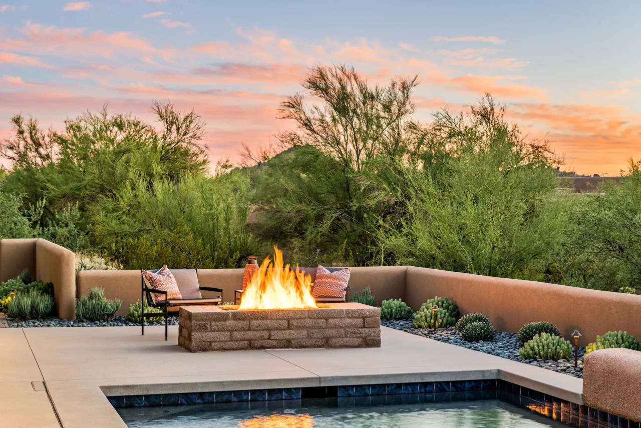 Shea-Naito Residence outdoor living space with fire pit and desert landscaping at sunset.