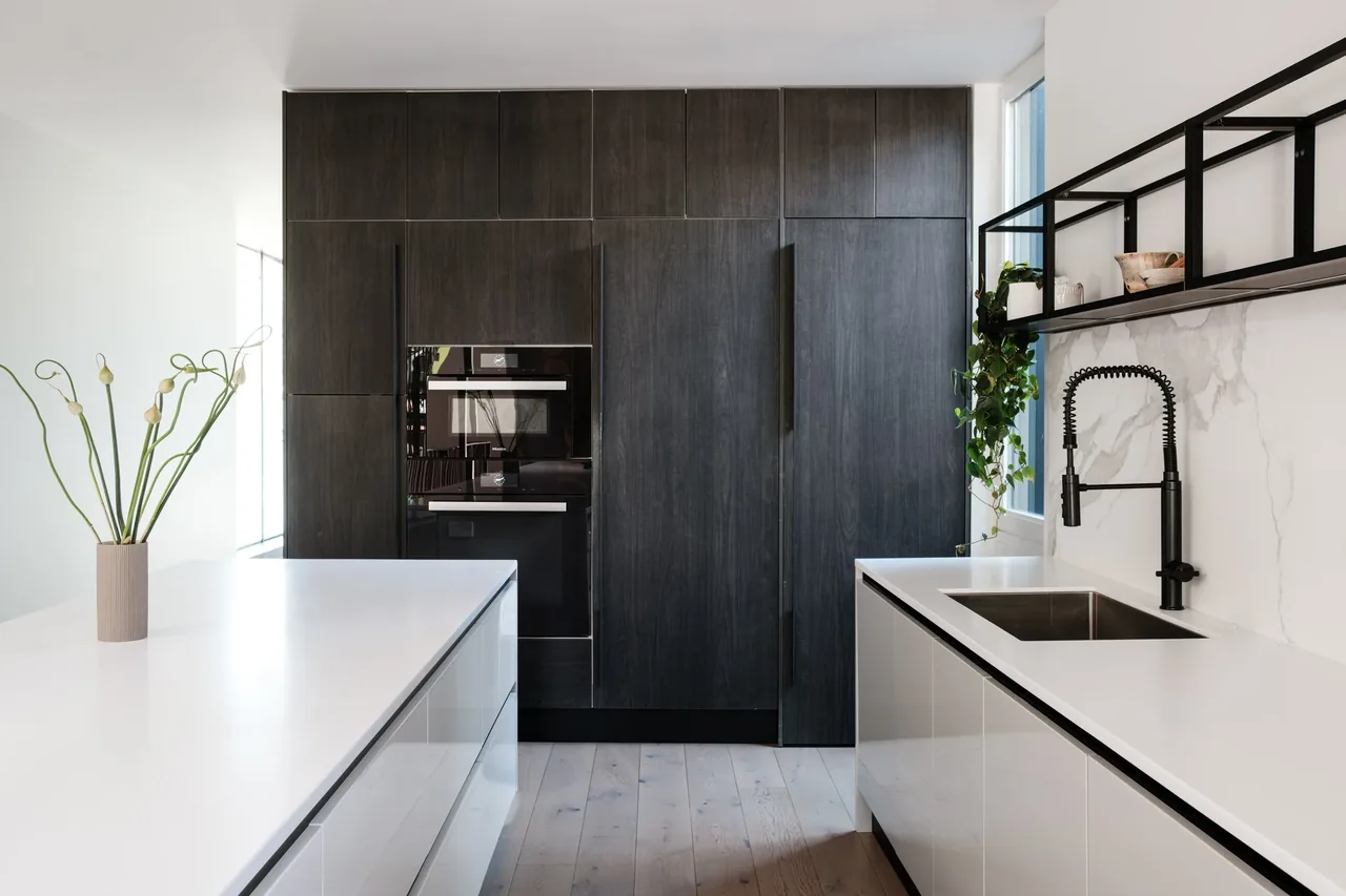 Kitchen features dark wood cabinets, white quartz countertops, black metal shelving, and a black spring coil faucet.