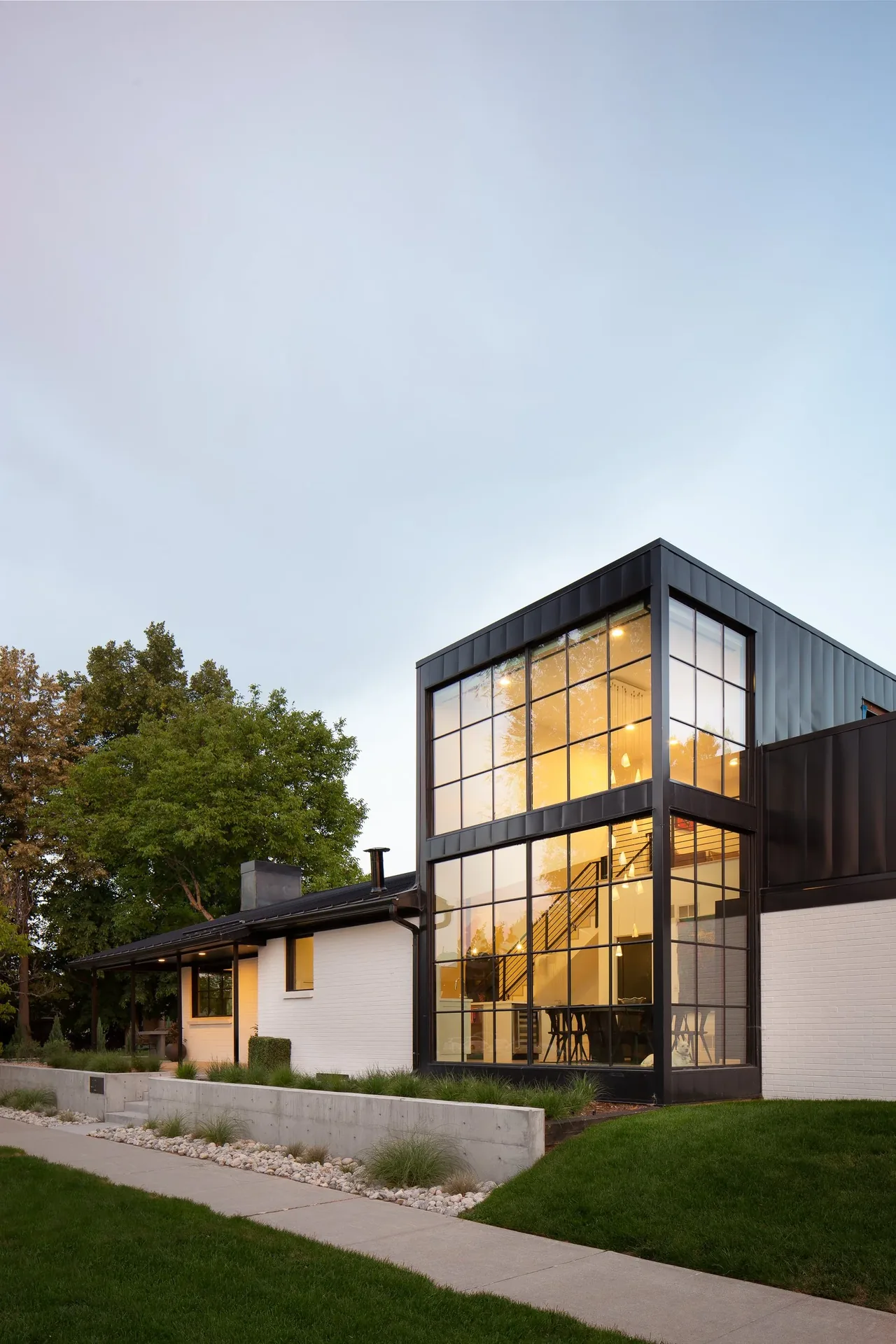 The Black and White House features a large vertical window grid and raised concrete planters along the front walkway.