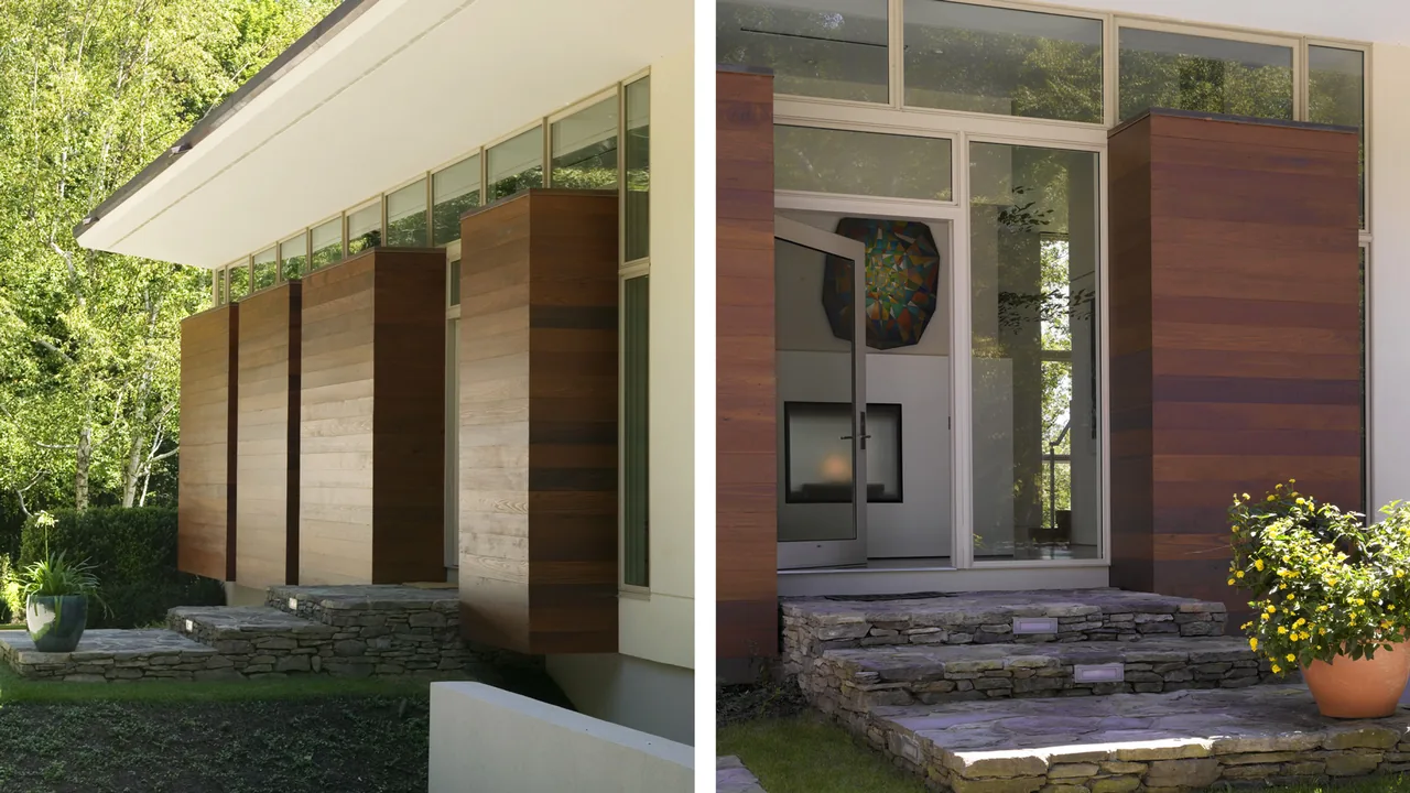 Front entrance of the Pawling Residence features stone retaining wall steps and vertical wood-clad elements under a wide overhang roof.