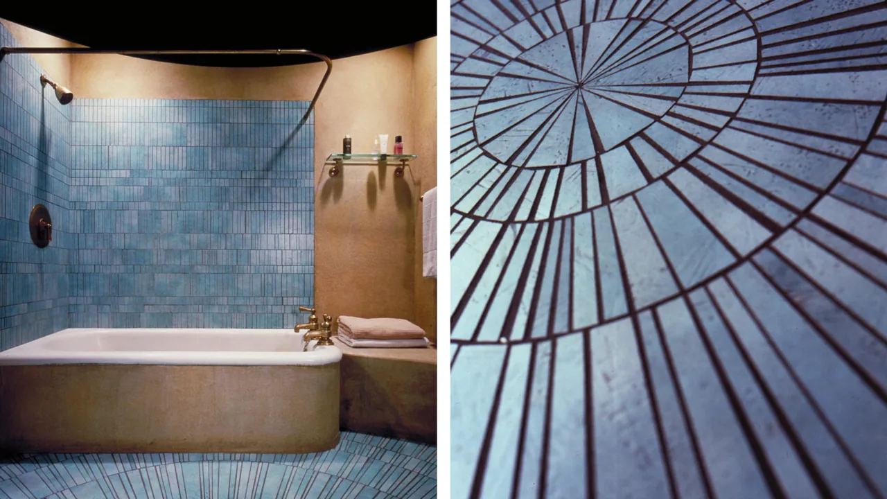Bathroom features blue vertical rectangular wall tiles and a circular tile pattern on the floor with a pedestal tub.