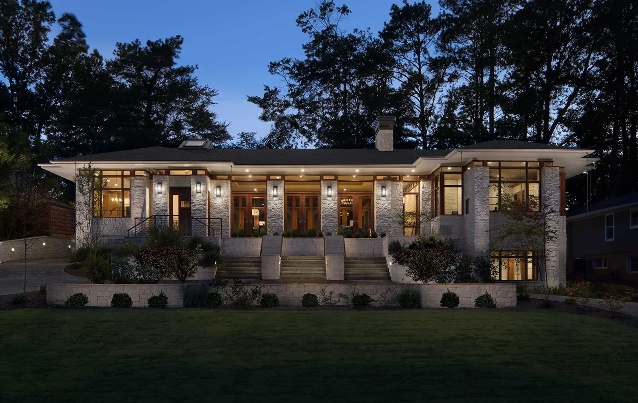 The Kittredge project features a modern low-profile home with stone pillar accents and expansive glazing framed in wood.