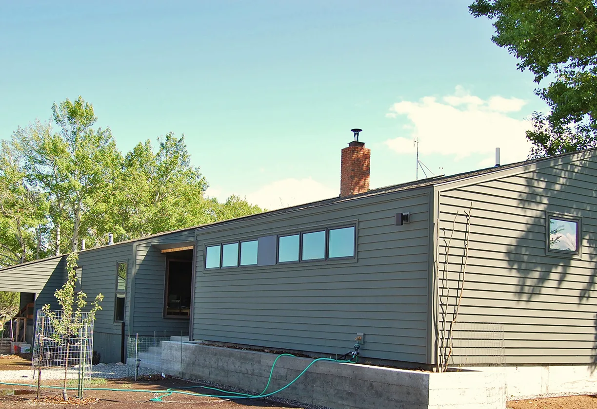 Spring Creek Residence features horizontal siding, a low-pitched roof, and large rectangular windows along one side.