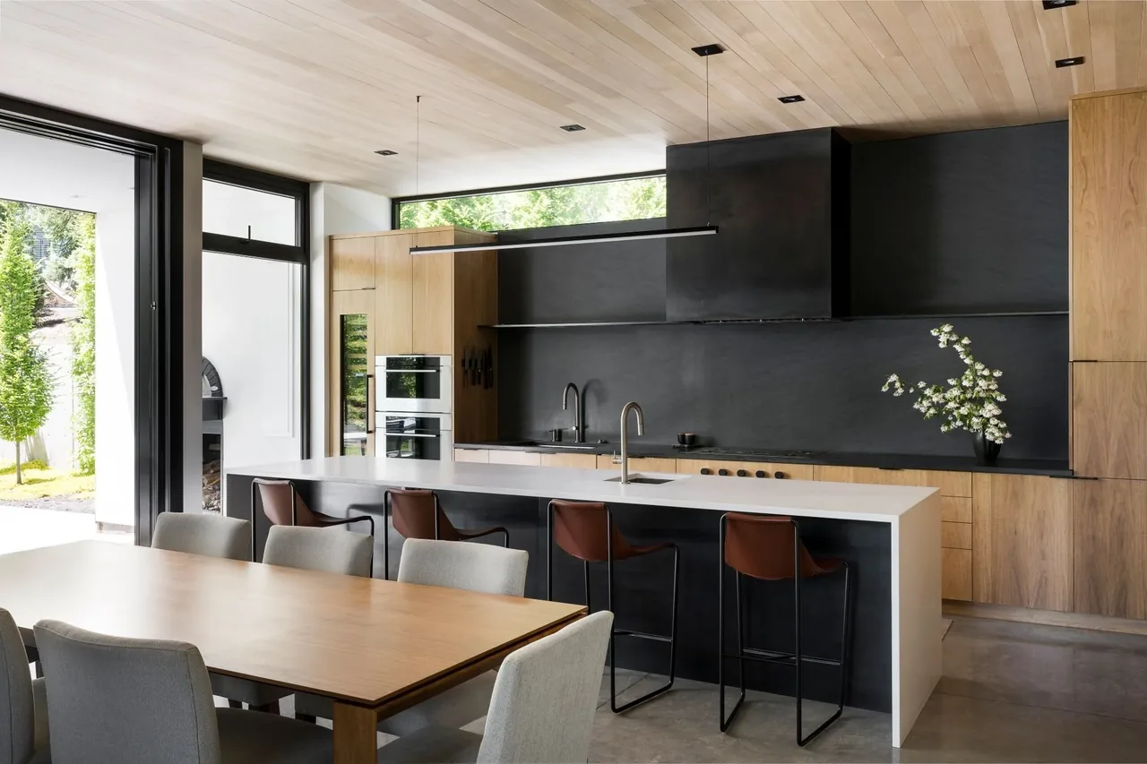 Emigration Creek Residence kitchen and dining area features wood cabinetry and ceiling with large kitchen island and natural light.