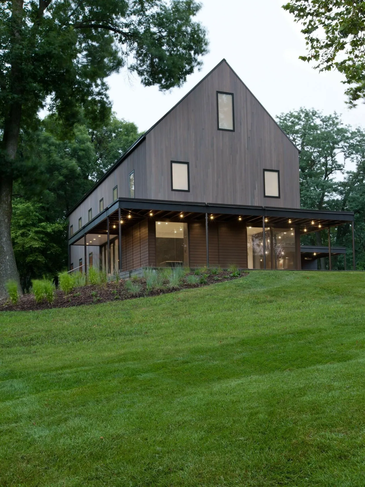 322 Reinvented features vertical wood siding and a covered patio with recessed lighting and sliding glass doors.