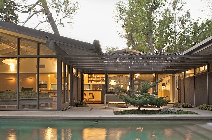 Canon Residence by Space International Inc. features large windows, exposed beams, and a raised deck next to a pool.
