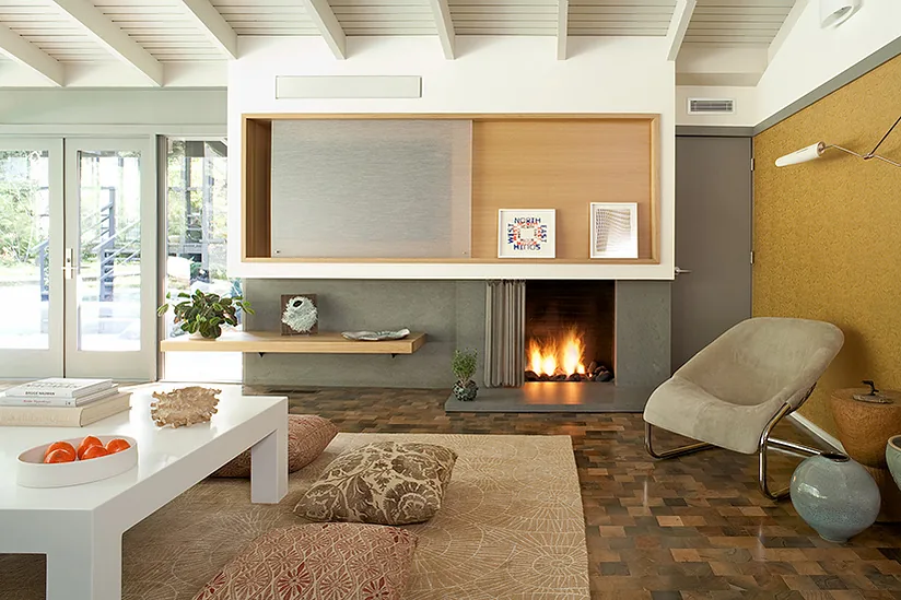 The living room features a parquet floor, built-in fireplace with wood storage, and a beige armchair against a yellow wall.