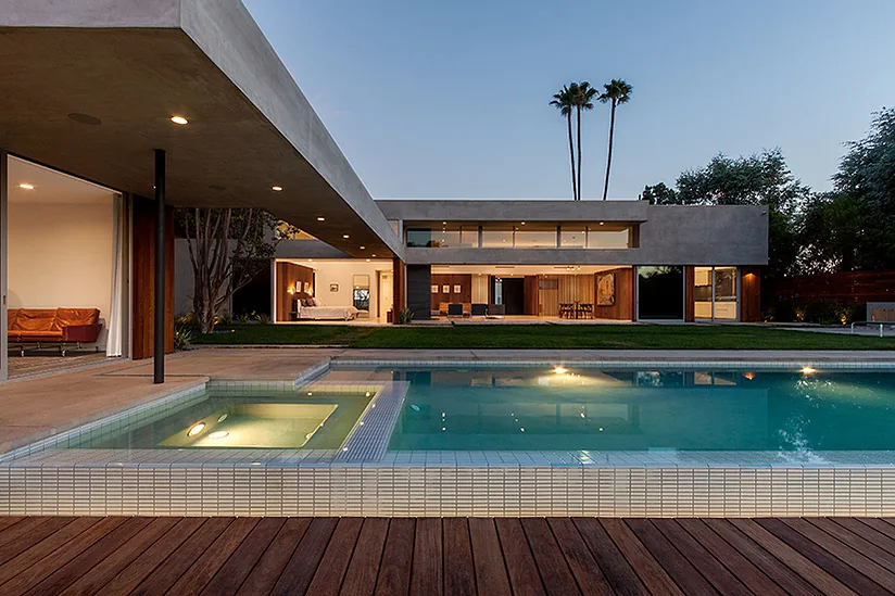 Arby Residence by Space International Inc. features a modern two-story design with exterior landscape lighting and a pool with attached spa.
