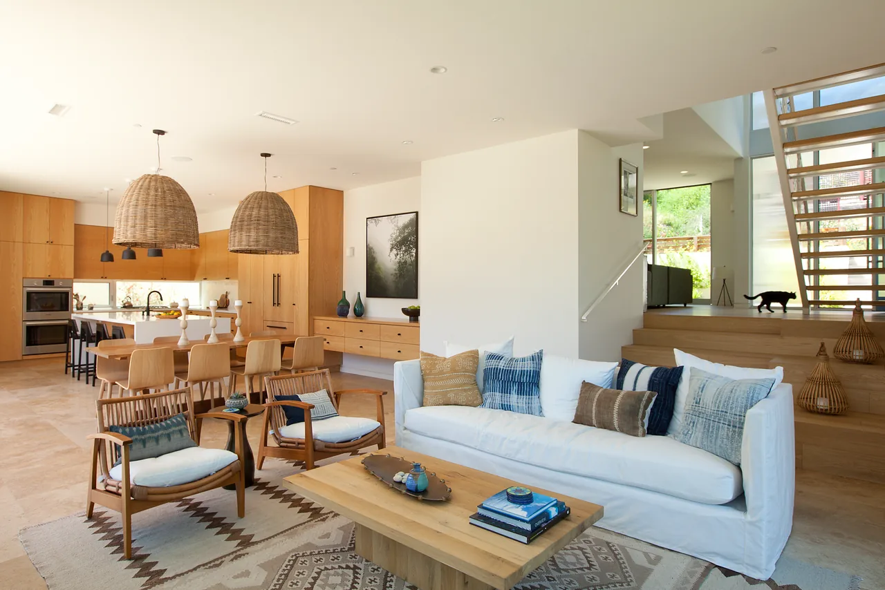 Open living and dining area in the Clark Street Private Residences featuring natural wood finishes and woven pendant lighting.