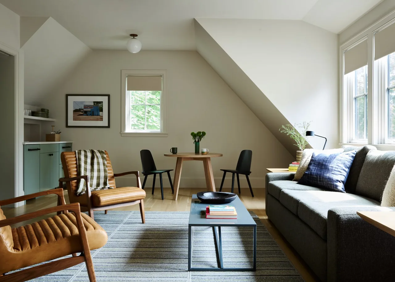 Contemporary living and dining area in Valentine House with gray sofa and wood furniture.