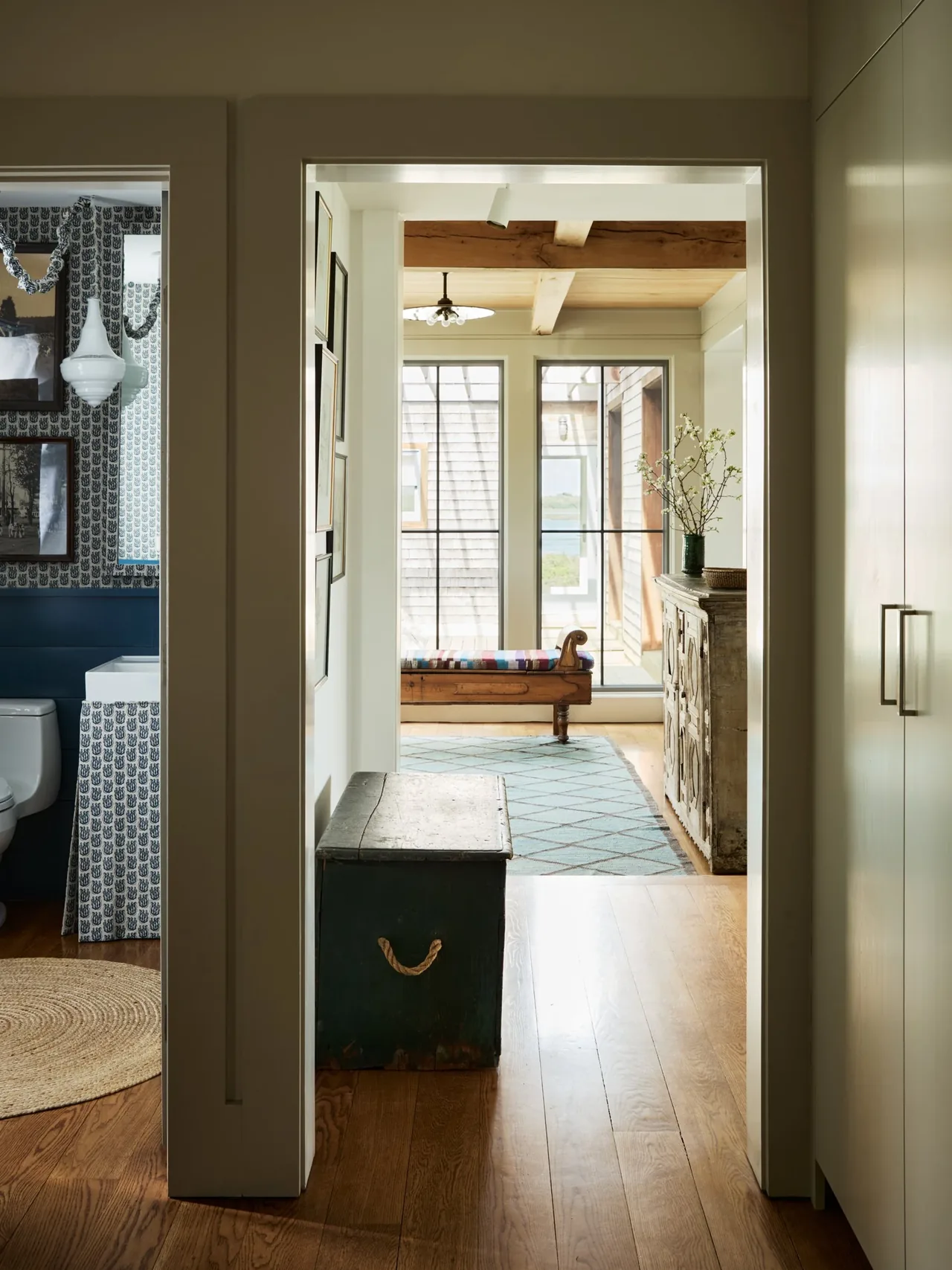 Interior view of Westport House showing a hallway leading to a room with wide wooden beams and large multi-pane windows.