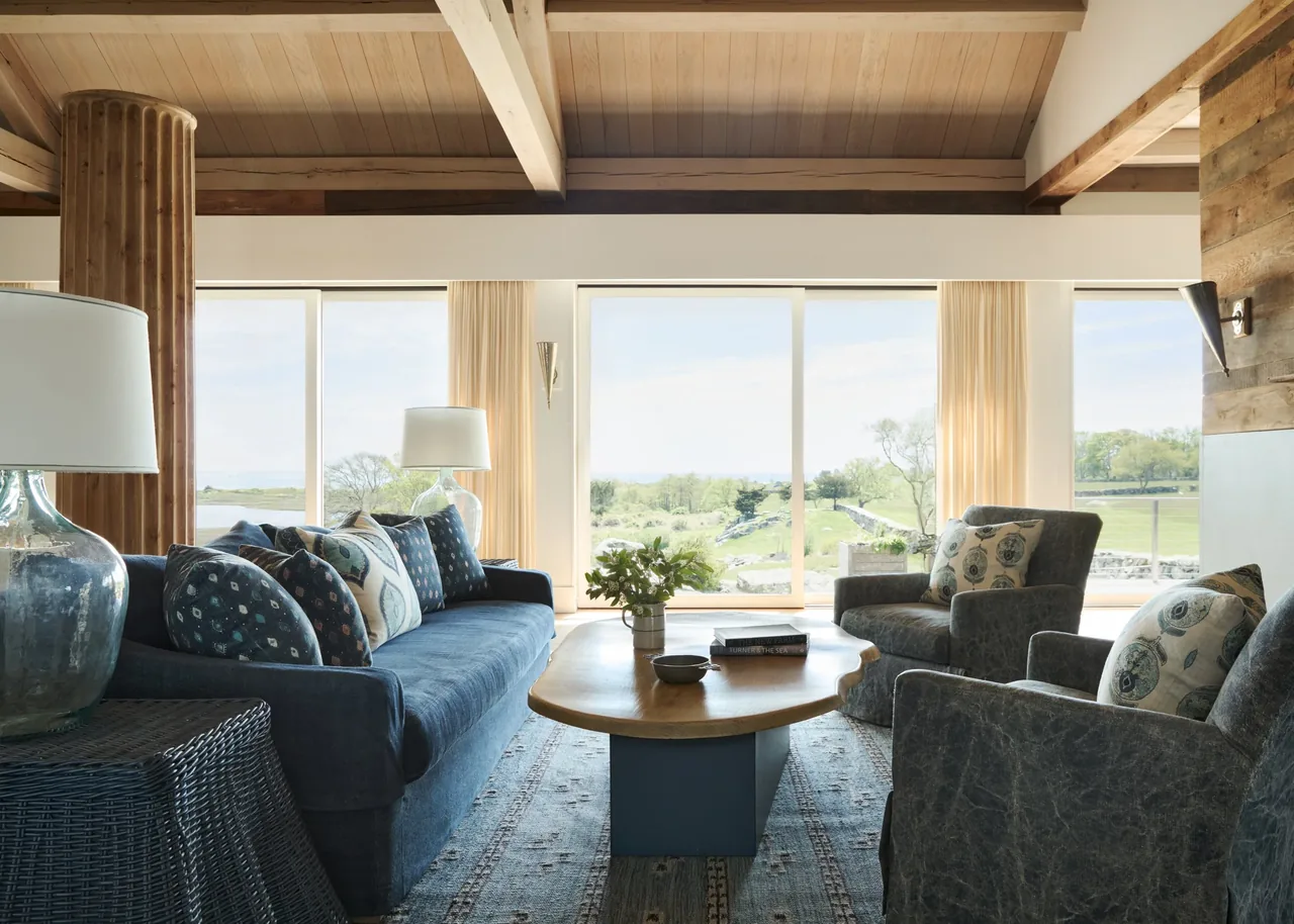 Westport House living room designed by Noury-Ello Architects features timber beams and large windows with views of the landscape.