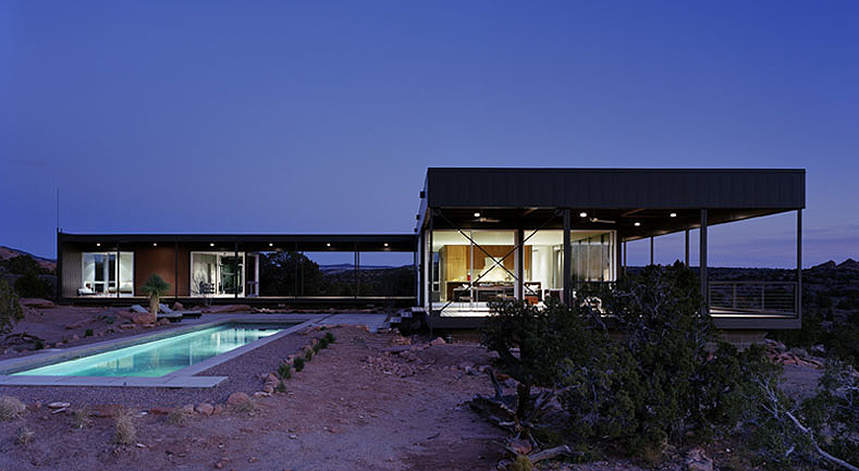 The Desert House features floor-to-ceiling glazing and a rectangular pool under a flat roof.