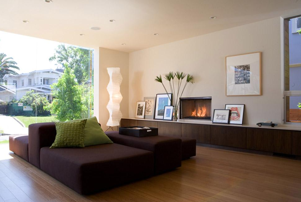 Living room features a built-in fireplace with dark wood cabinetry and a large window overlooking greenery.