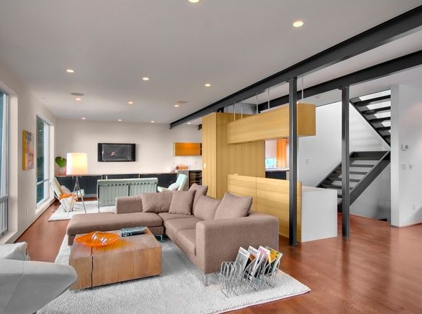 Living room in the Queen Anne House with modern furnishings and an open black metal staircase.