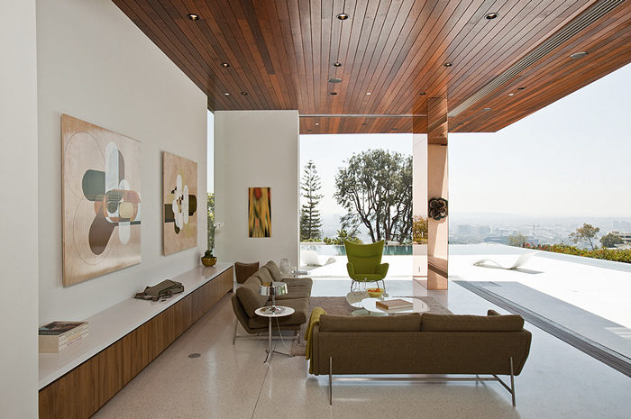 Sunset Plaza Residence living room with wood-paneled ceiling, open to outdoor area featuring glass railing and cityscape views.