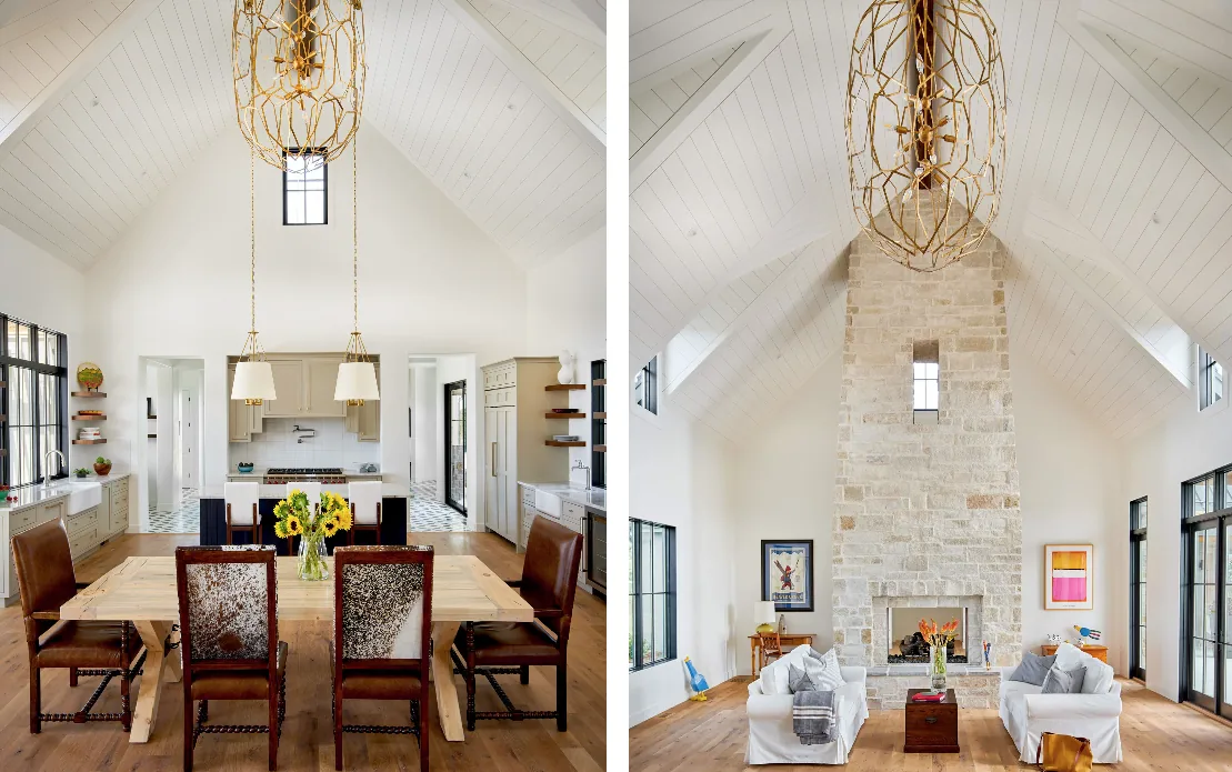 The home features a vaulted ceiling with white plank paneling, a stone fireplace, and black-framed windows in the combined living and kitchen areas.