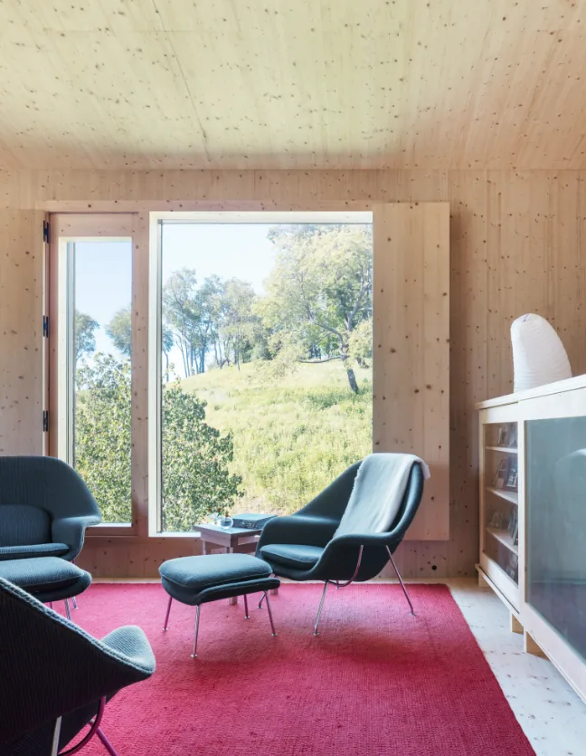 Hudson Valley House II living room featuring wood paneling and a large window with nature views.