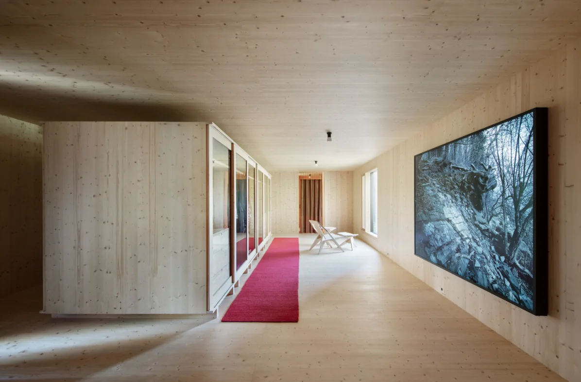 Hudson Valley House II features a minimalist wood interior with expansive wall paneling and integrated media display.