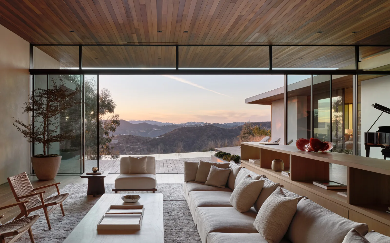 The Carla Ridge House living room features floor-to-ceiling glazing with views of surrounding hills.