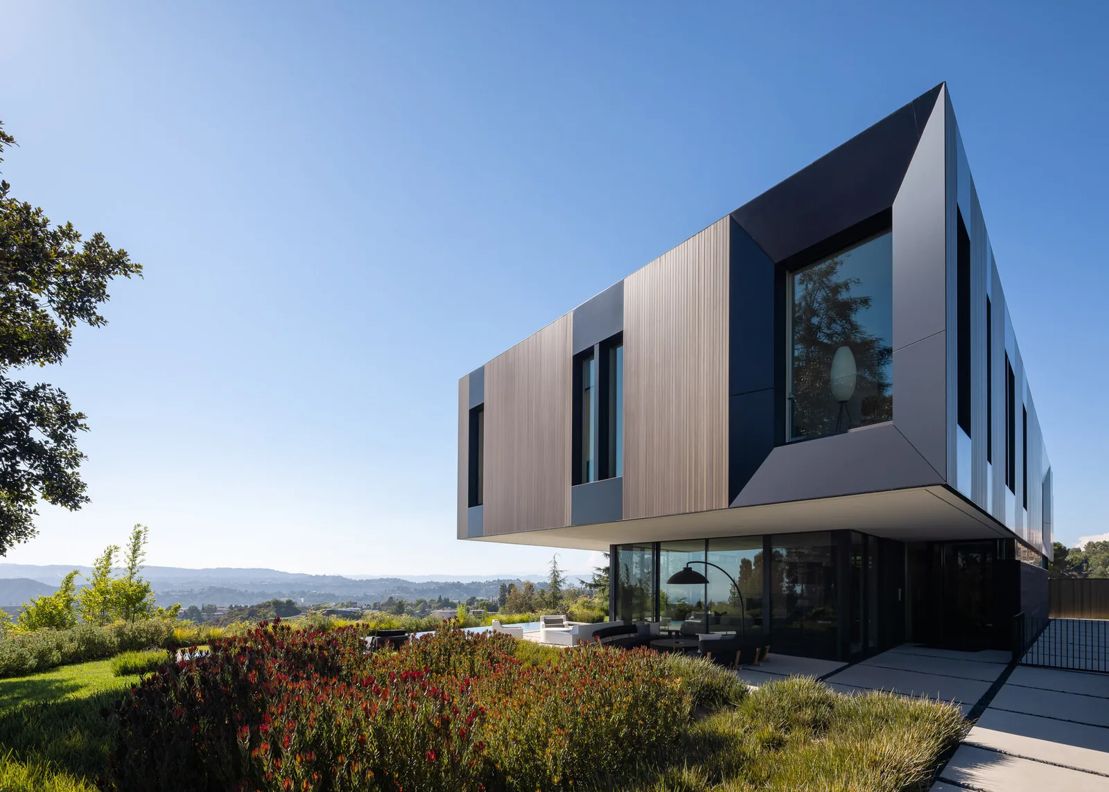 Bronze and Black House features a cantilevered upper floor with bronze paneling and black framing.