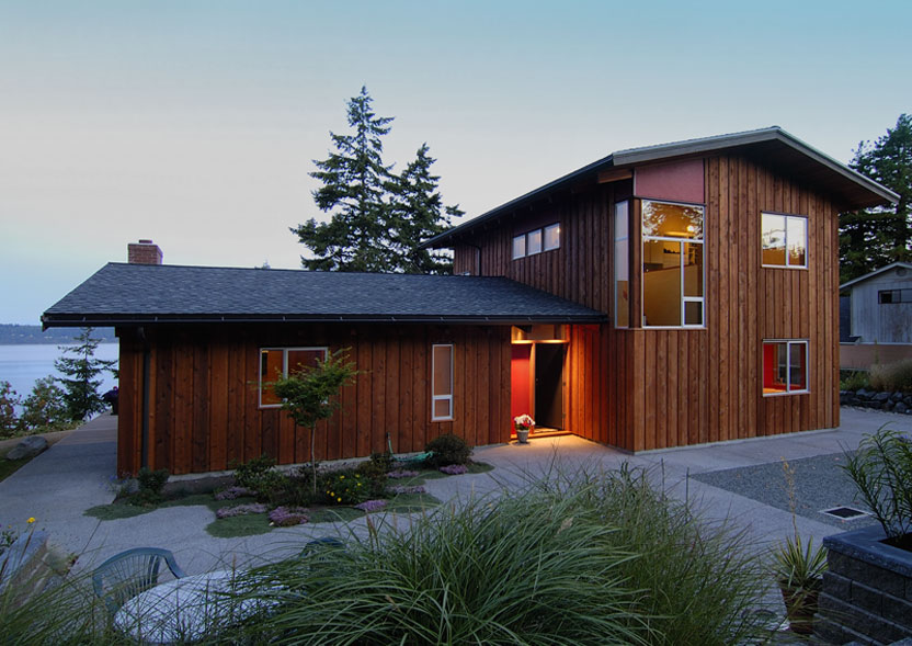 The Omnell Residence shows wood siding, multiple windows, and a pitched roof with outdoor lighting at the entry.
