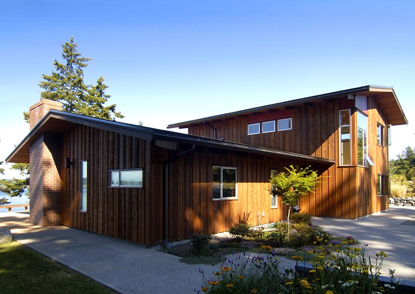 The Omnell Residence features vertical wood siding with multiple pitched roofs and large windows including corner windows.