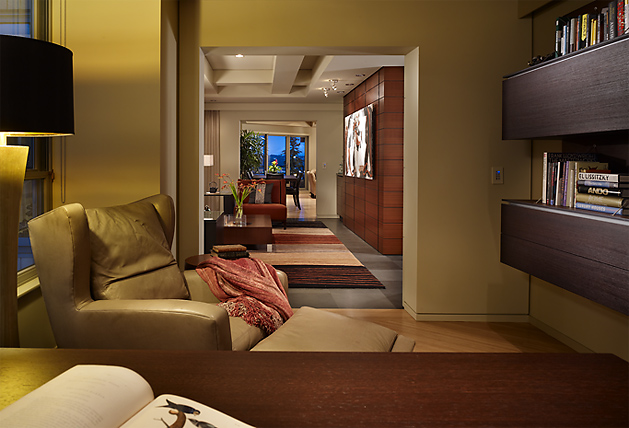 Interior view of Watermark Tower Condominium showing a living and dining area with wood paneling and modern furnishings.