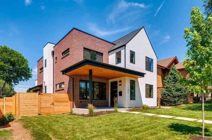 Two-story modern house with red brick and white stucco exterior under a pitched roof.