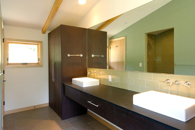 Modern bathroom interior with double vessel sinks, large mirror, and wooden beams on ceiling.