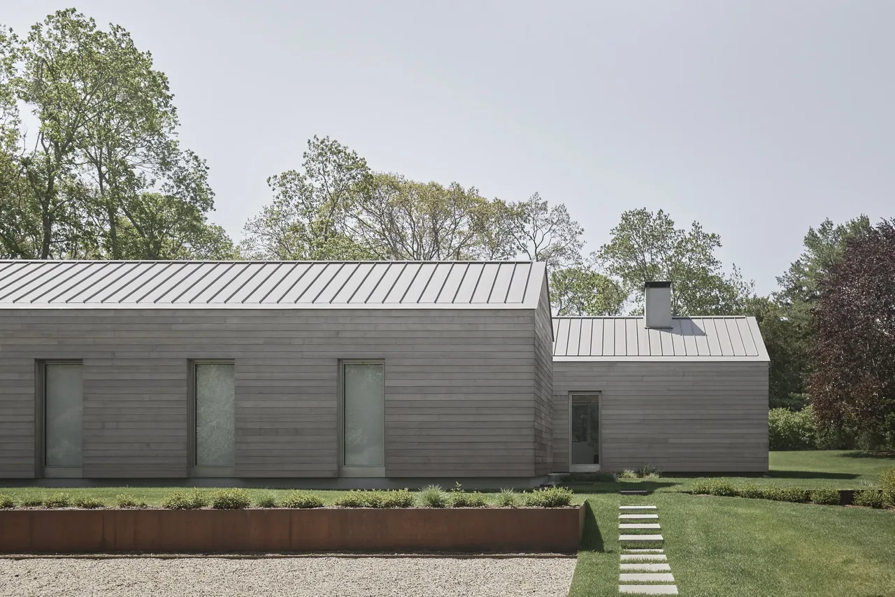Exterior view of a modern residence with horizontal wood siding and standing seam metal roof.