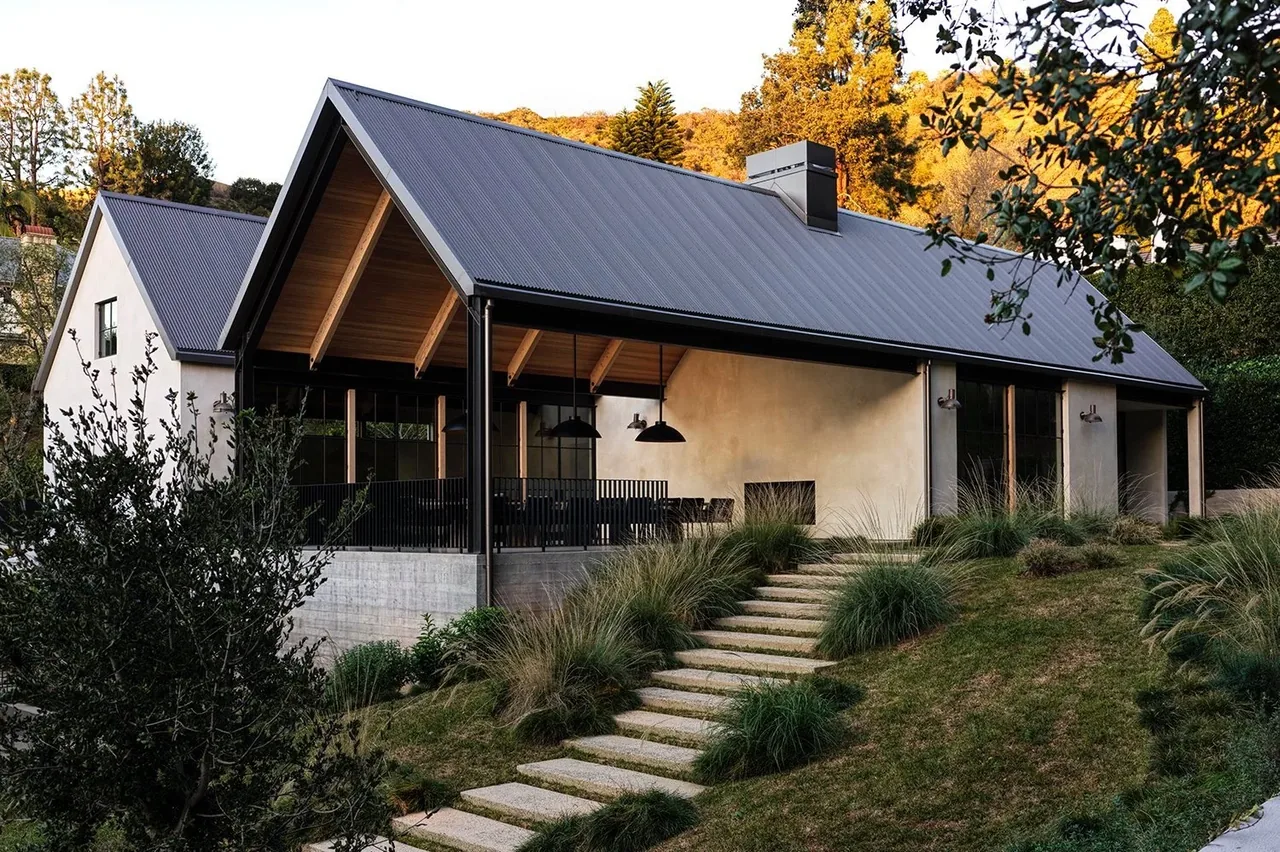 Exterior view of Canyon House showing a modern gable roof and stucco walls with an elevated covered patio.