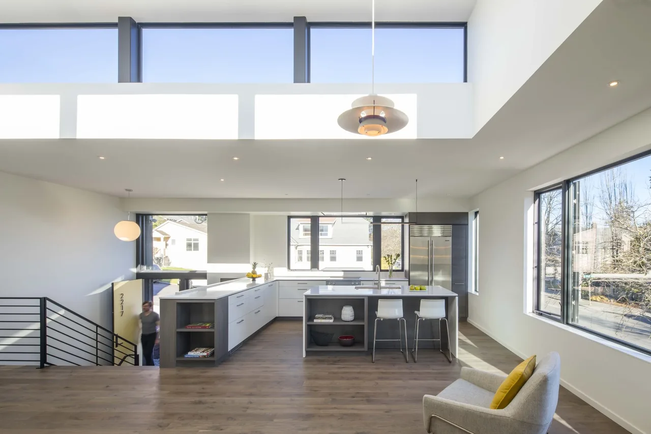 Bright modern kitchen and living area with large windows and high clerestory windows near the ceiling