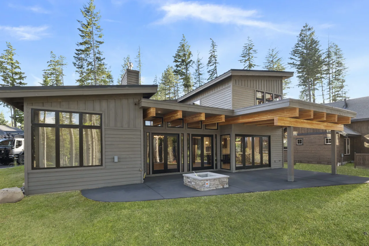 Rear exterior view of a modern home with a covered patio and large windows