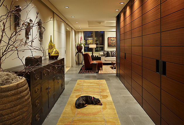 Interior hallway with wood paneling and a dog lying on a yellow area rug.